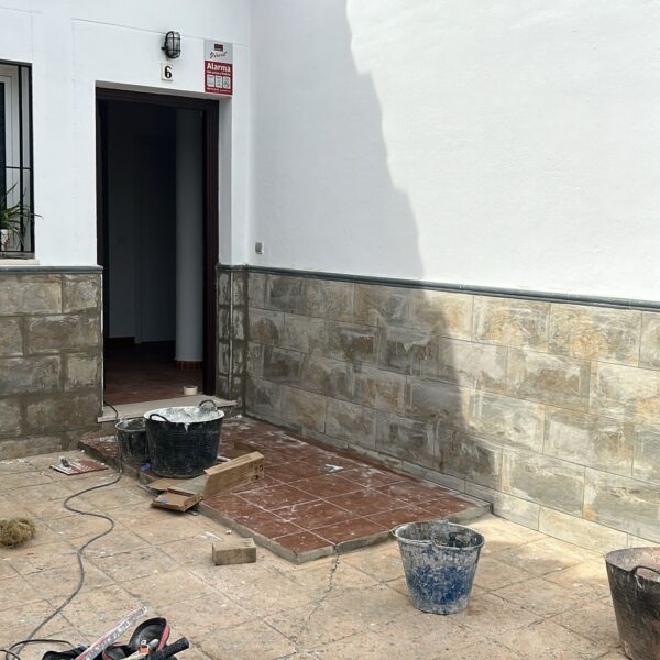 Revestimiento de pared con z贸calo de azulejo en reforma de vivienda en Sevilla. Instalaci贸n de z贸calo de azulejo en pared de sal贸n moderno en Sevilla, por Orosuelo Reformas Integrales