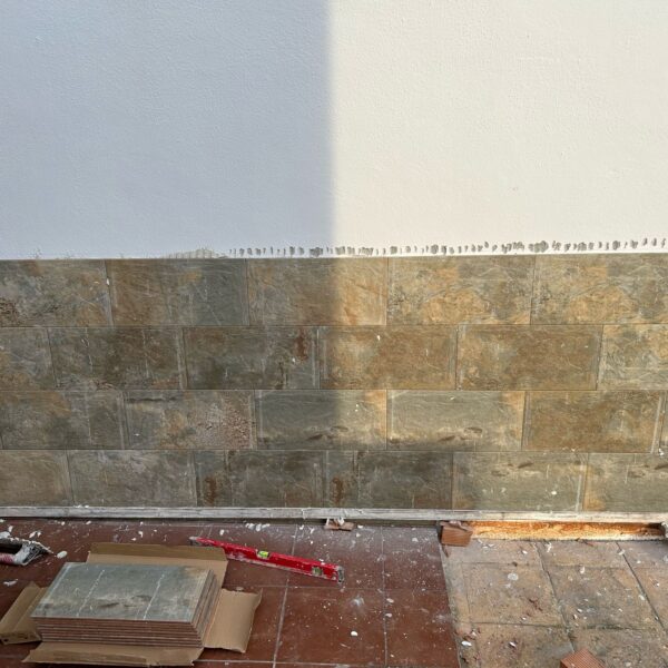 Revestimiento de pared con z贸calo de azulejo en reforma de vivienda en Sevilla. Instalaci贸n de z贸calo de azulejo en pared de sal贸n moderno en Sevilla, por Orosuelo Reformas Integrales