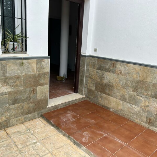 Revestimiento de pared con z贸calo de azulejo en reforma de vivienda en Sevilla. Instalaci贸n de z贸calo de azulejo en pared de sal贸n moderno en Sevilla, por Orosuelo Reformas Integrales